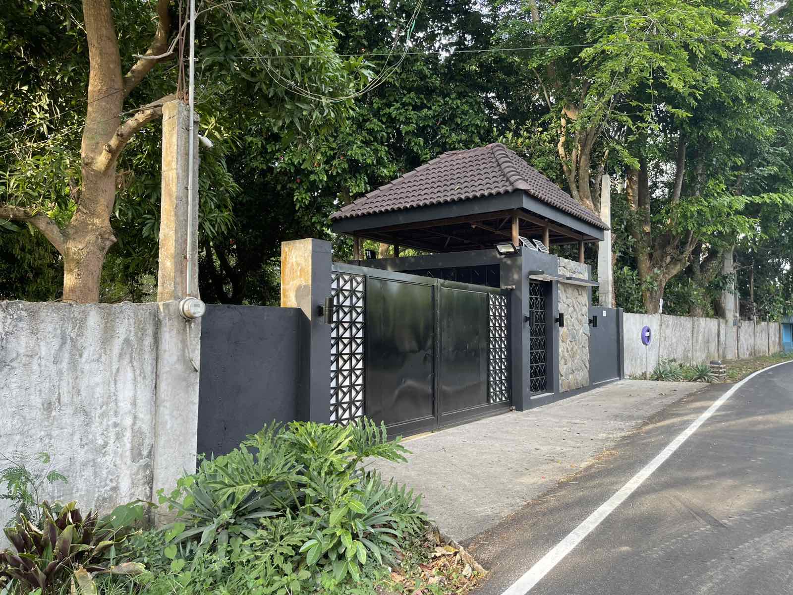Resort entrance gate with traditional Filipino architecture and lush landscaping